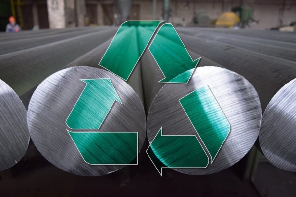 Aluminiumstangen liegen nebeneinander, darüber gemalt ist ein grünes Recycling-Zeichen