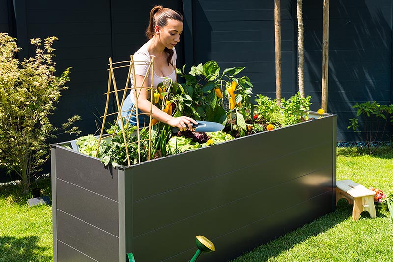 hochwertiges hochbeet wetterfest perfekt fuer den garten mit frau bei der gartenarbeit